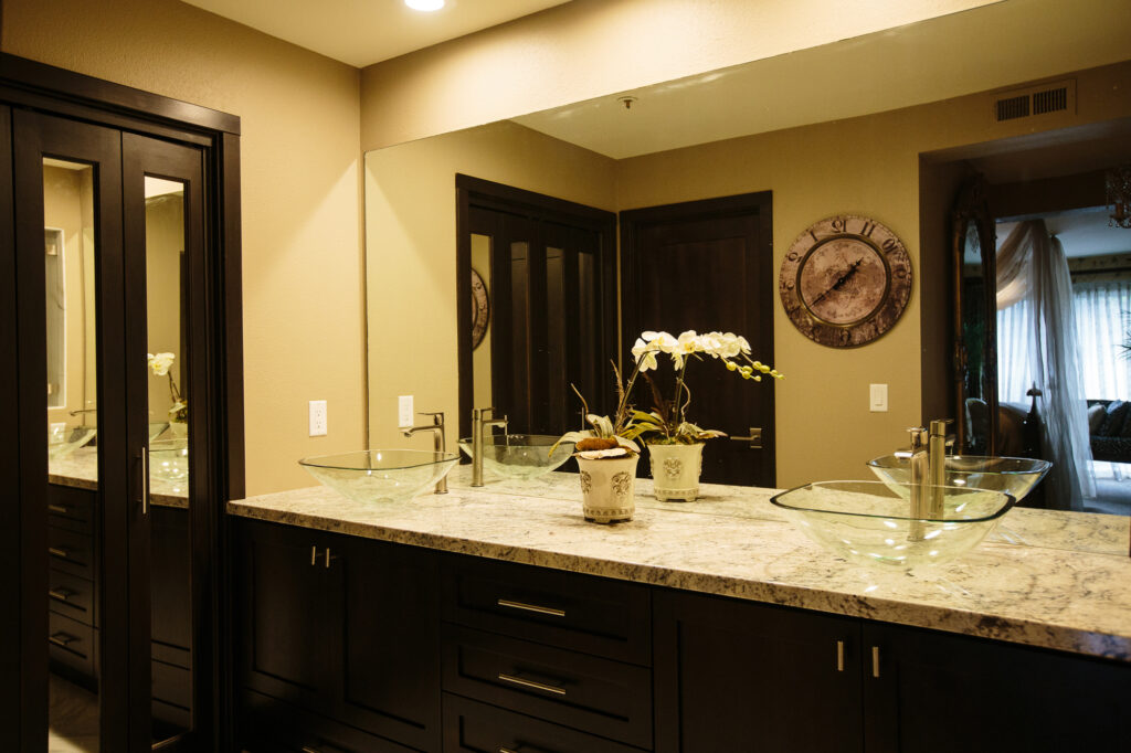 Two hand blown glass vessel sinks and over sized shower surrounded by Calacatta Oro marble creates a total Euro-spa feel.
