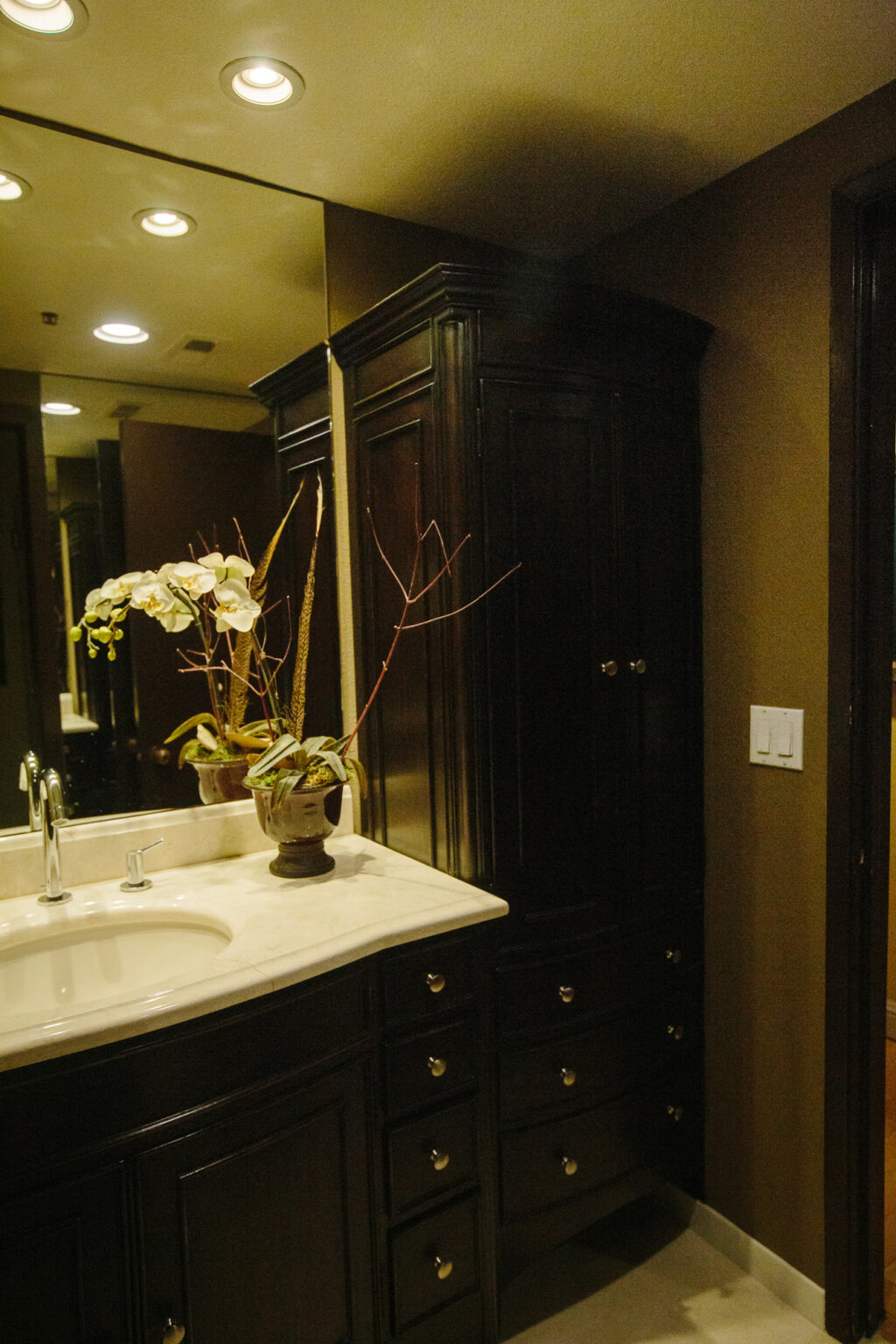 Black Traditional bowed front full height cabinetry, sculpted marble counter top, custom cocoa wall paint are element of transitional interior design.